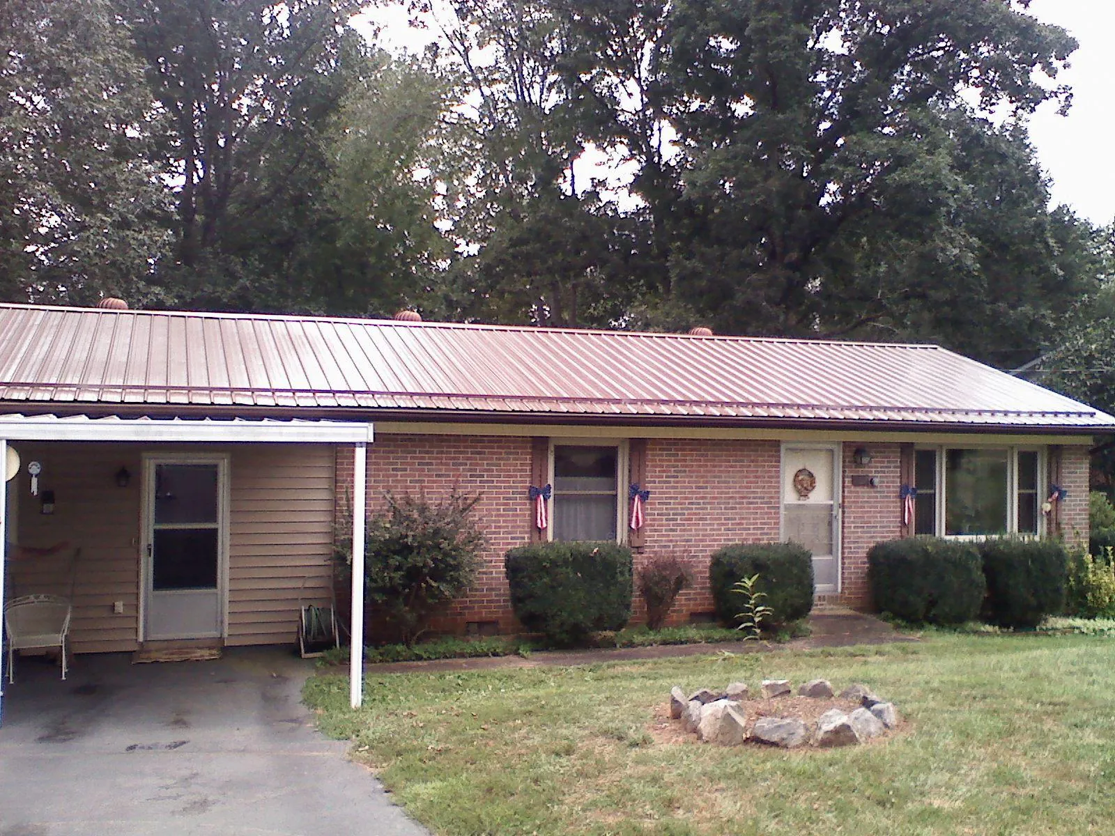 Bronze metal roof and carport on a brick ranch home — Roof Repair work by our crew in Rocky Point