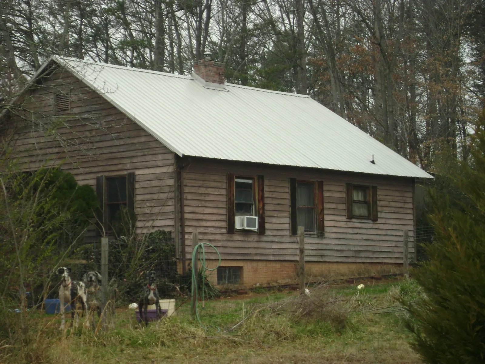 White metal roof on an old wood sided farmhouse, from a Metal Roof Installation job in Rocky Point